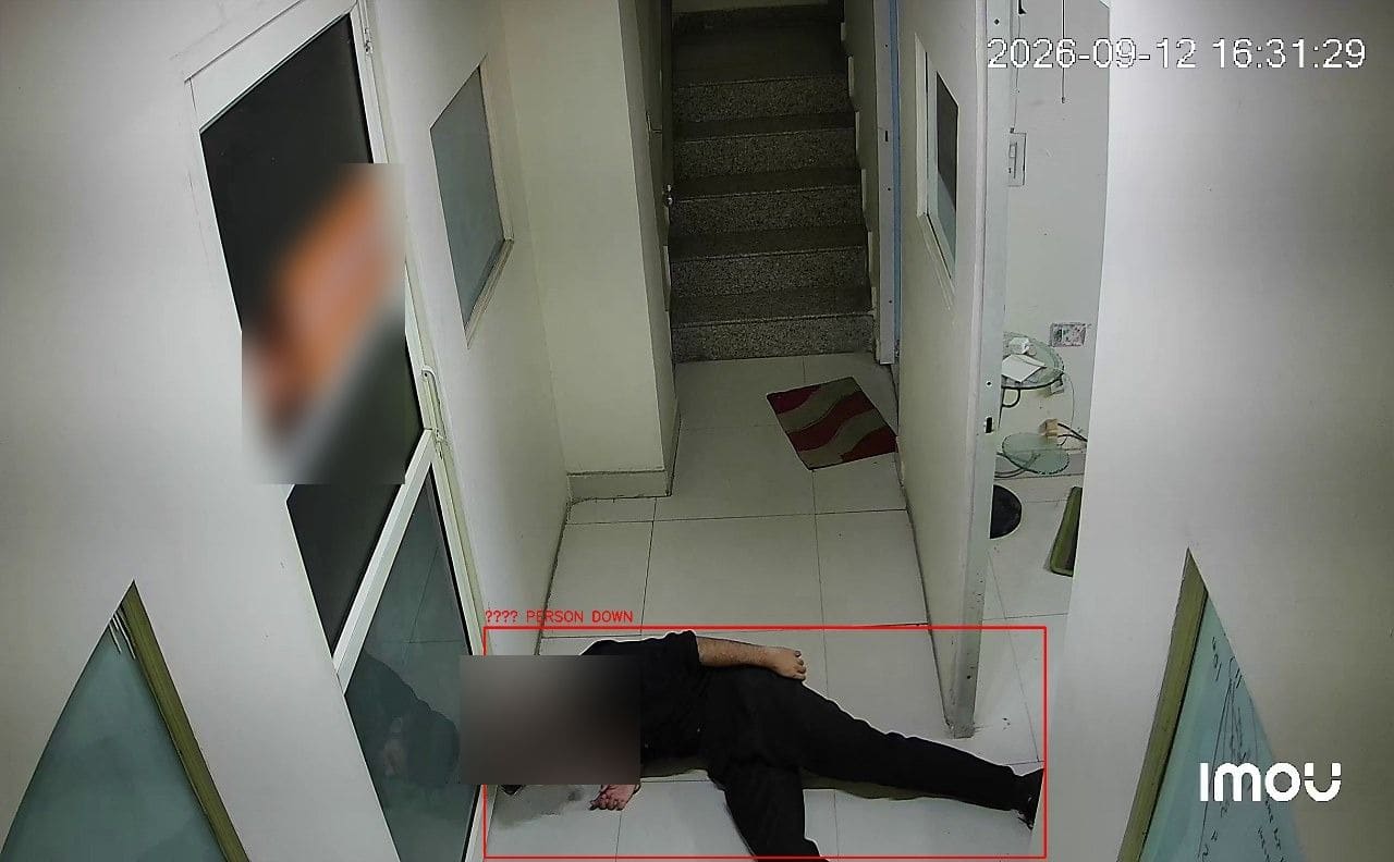 A person lying on a corridor floor labeled person down, face blurred